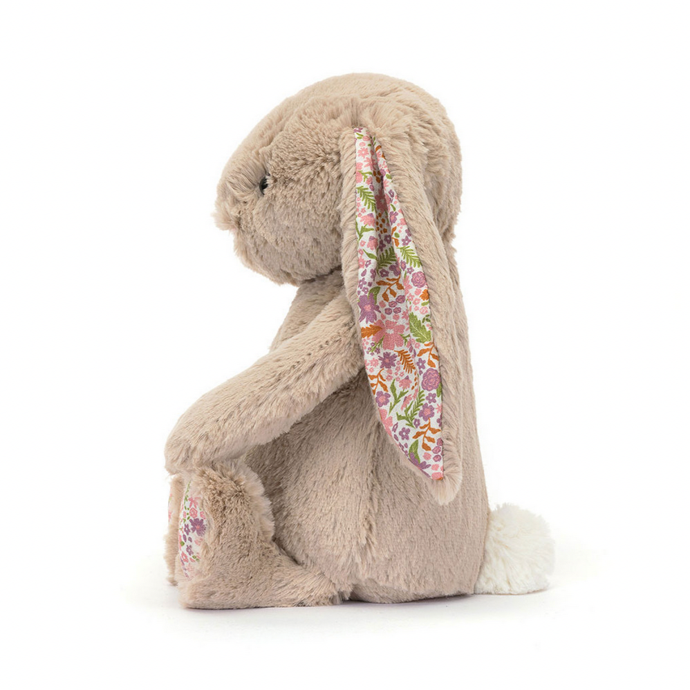 Stuffed bunny toy with floral ear on a white background