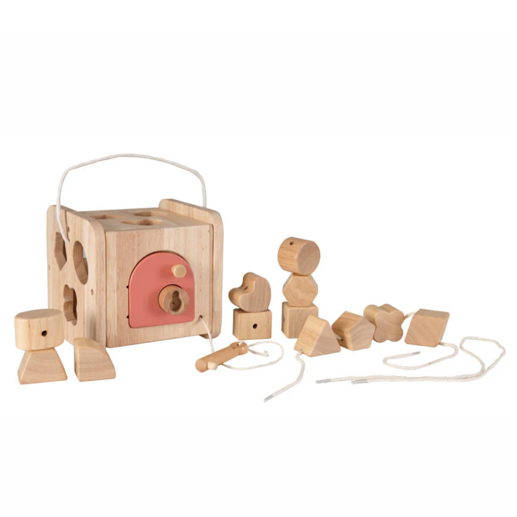 Wooden toys including a shape sorter and blocks on a white background