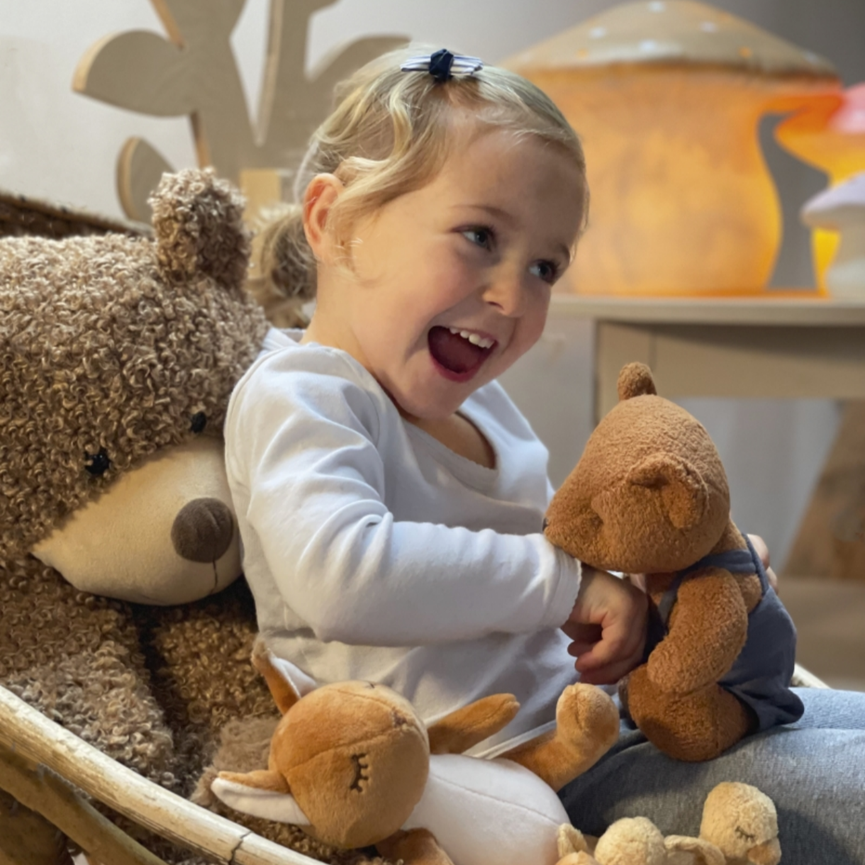 Child playing with teddy bears in a cozy room