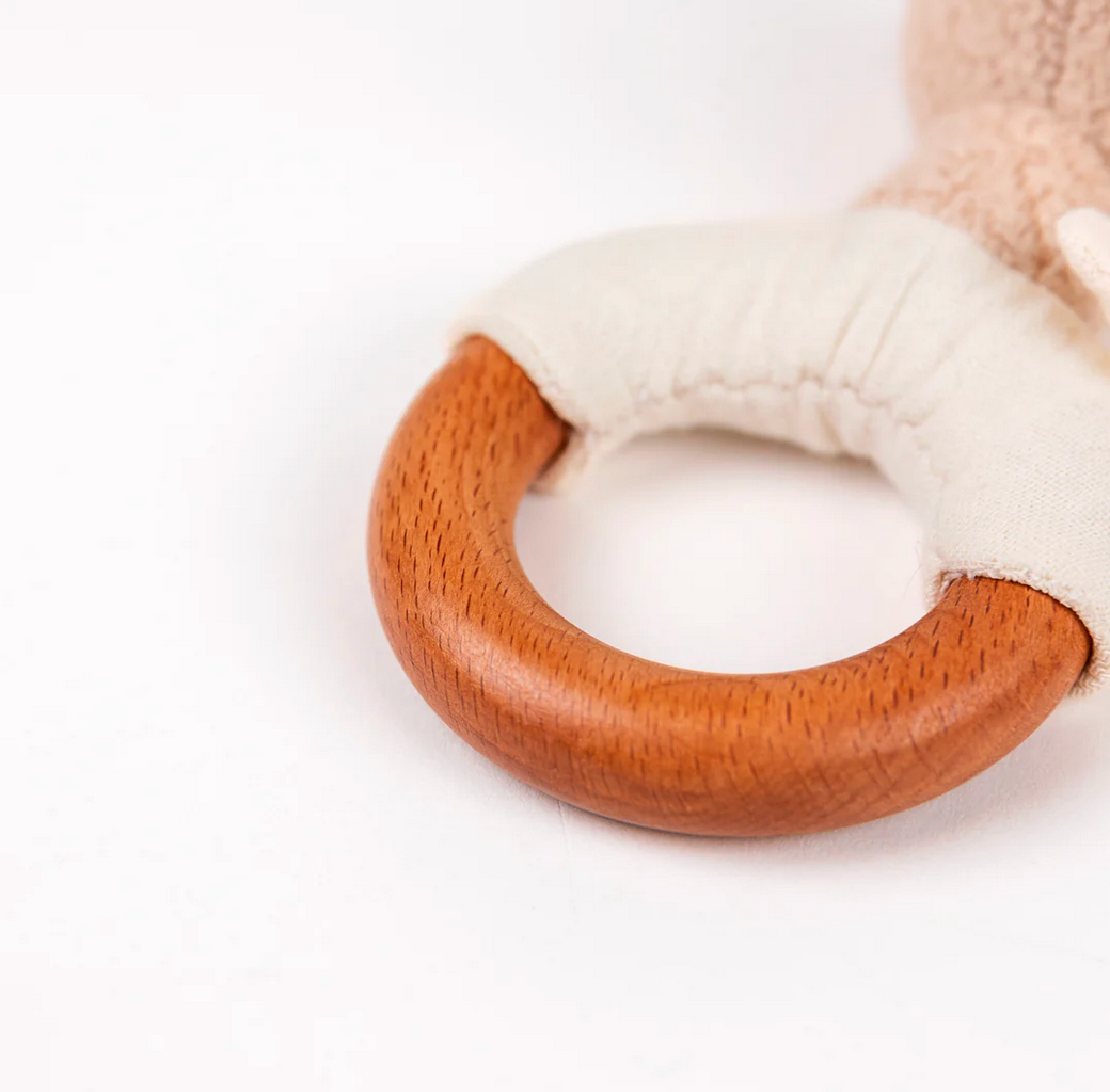 Wooden ring with a plush white handle on a light background
