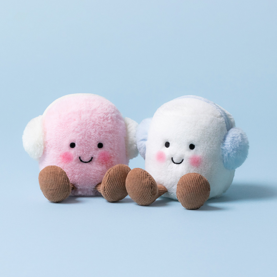 Two plush toys, one pink and one white, on a light blue background