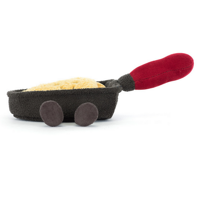 Toy resembling a miniature frying pan with a red handle on a white background