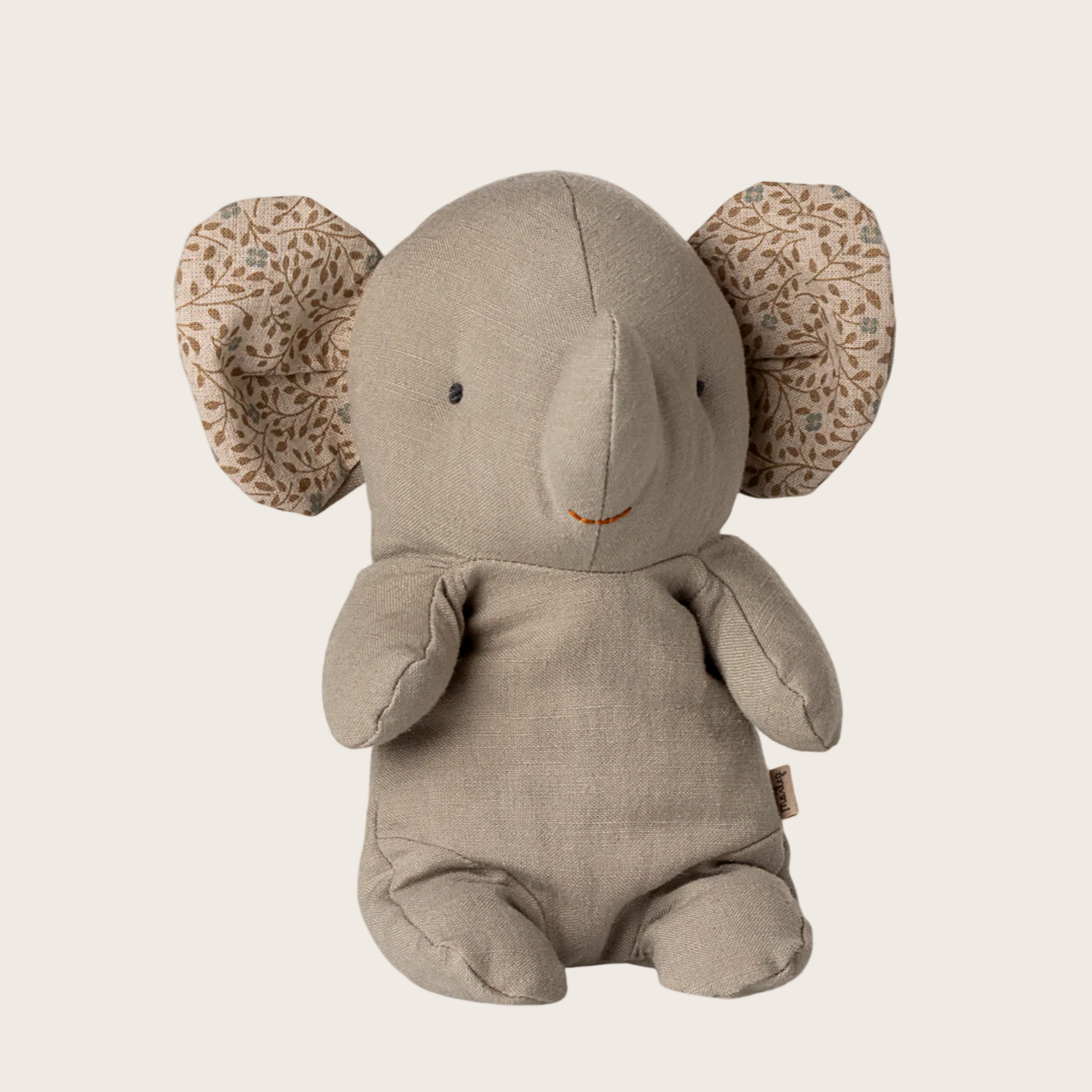 Plush elephant toy with patterned ears on a beige background