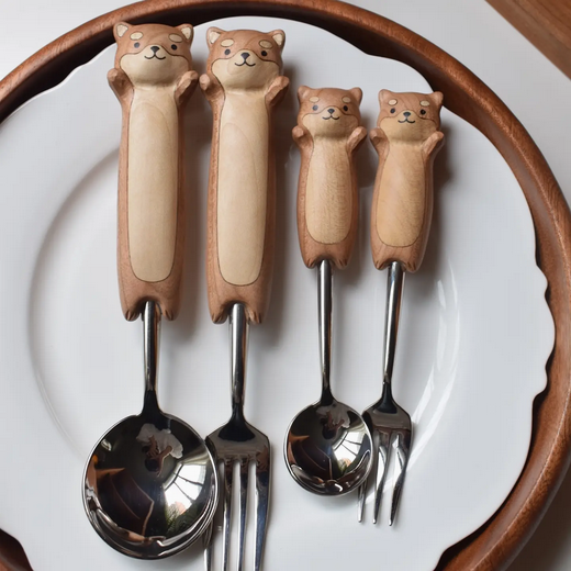 Four spoons and forks with dog-shaped handles on a white plate.