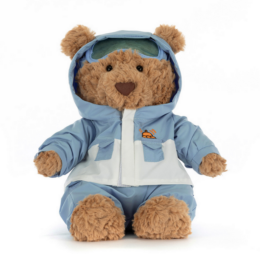Teddy bear wearing a blue snowsuit on a white background