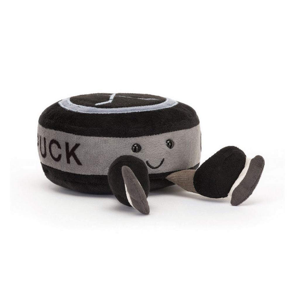 Plush toy hockey puck with a smiling face on a white background