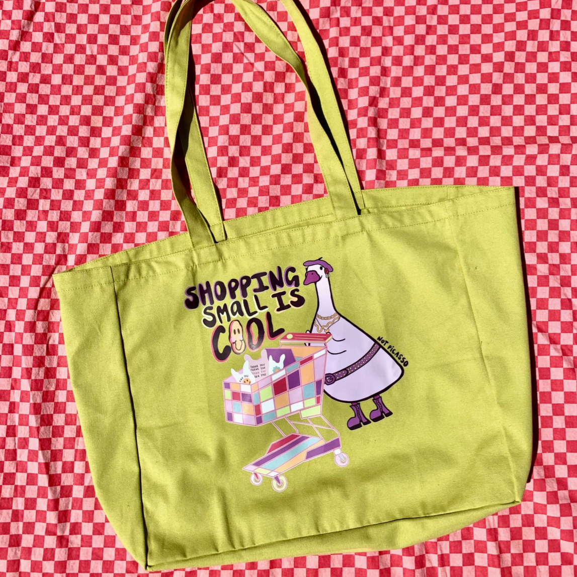 Green tote bag with cartoon design on a red and white checkered background