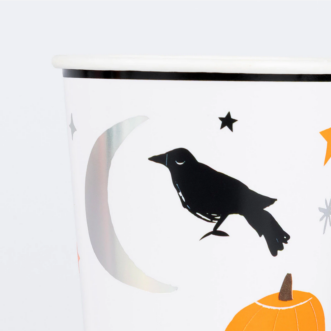 Halloween-themed mug with a crow, moon, and pumpkin design on a white background