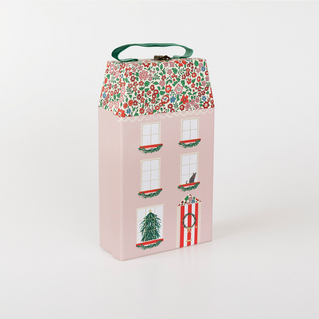 Decorative pink house-shaped box with festive design on a white background
