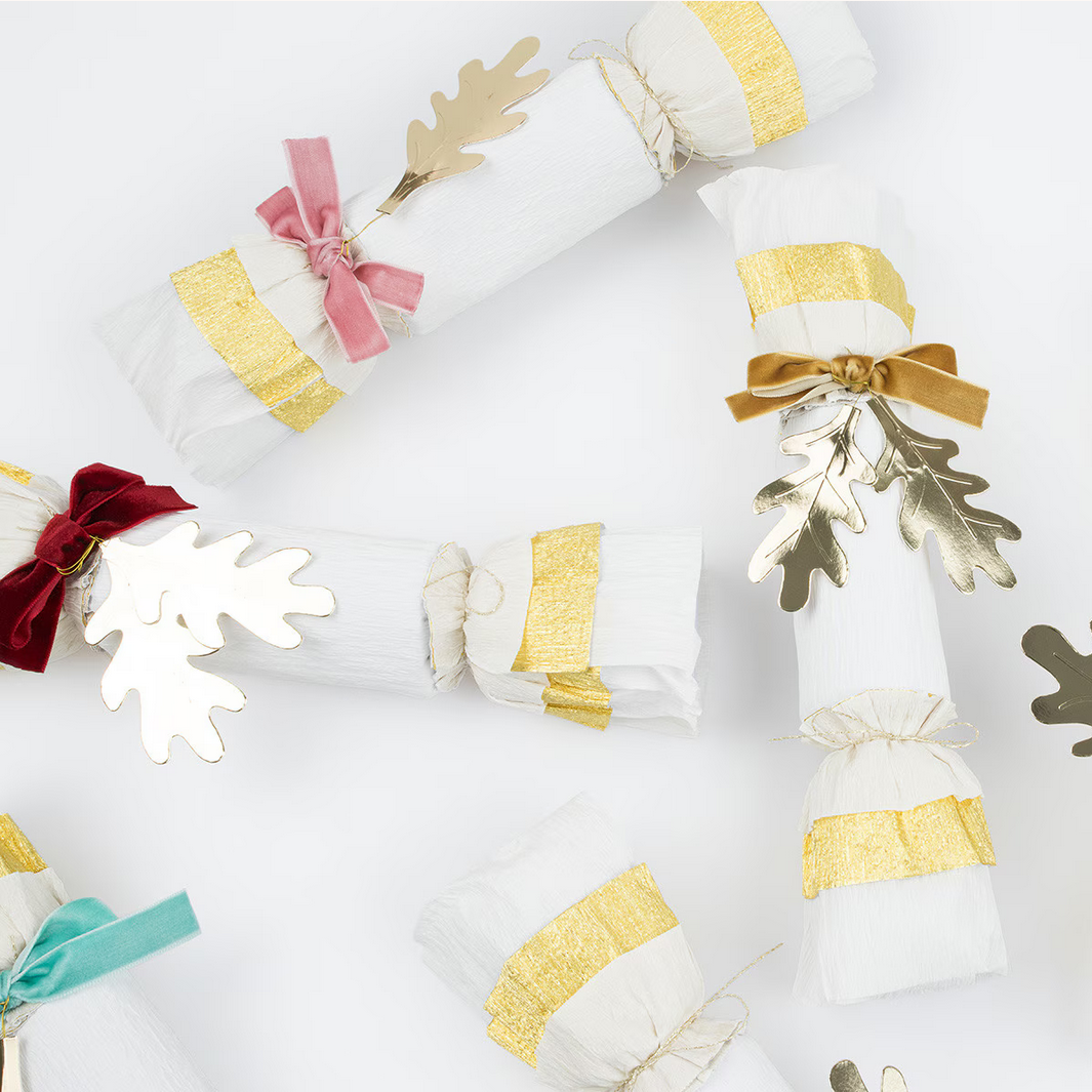 Decorative cracker with gold and red ribbons on a white background