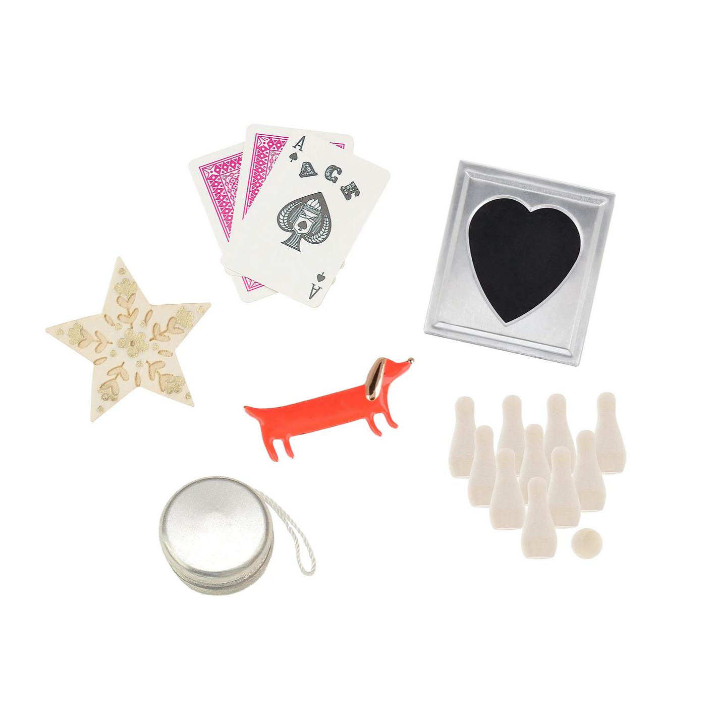 Collection of various small items including playing cards, a star-shaped object, a dog figurine, a heart-shaped container, a silver compact mirror, and small white bottles on a white background.
