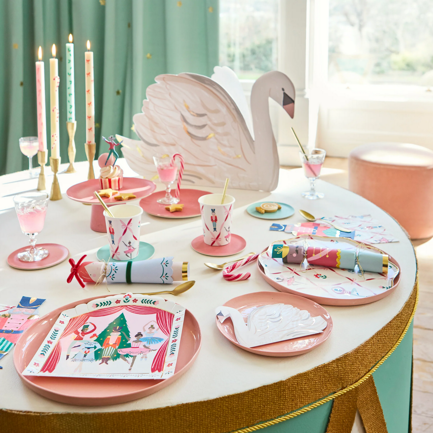 Decorative table setting with pink plates, flamingo cake, and festive candles.