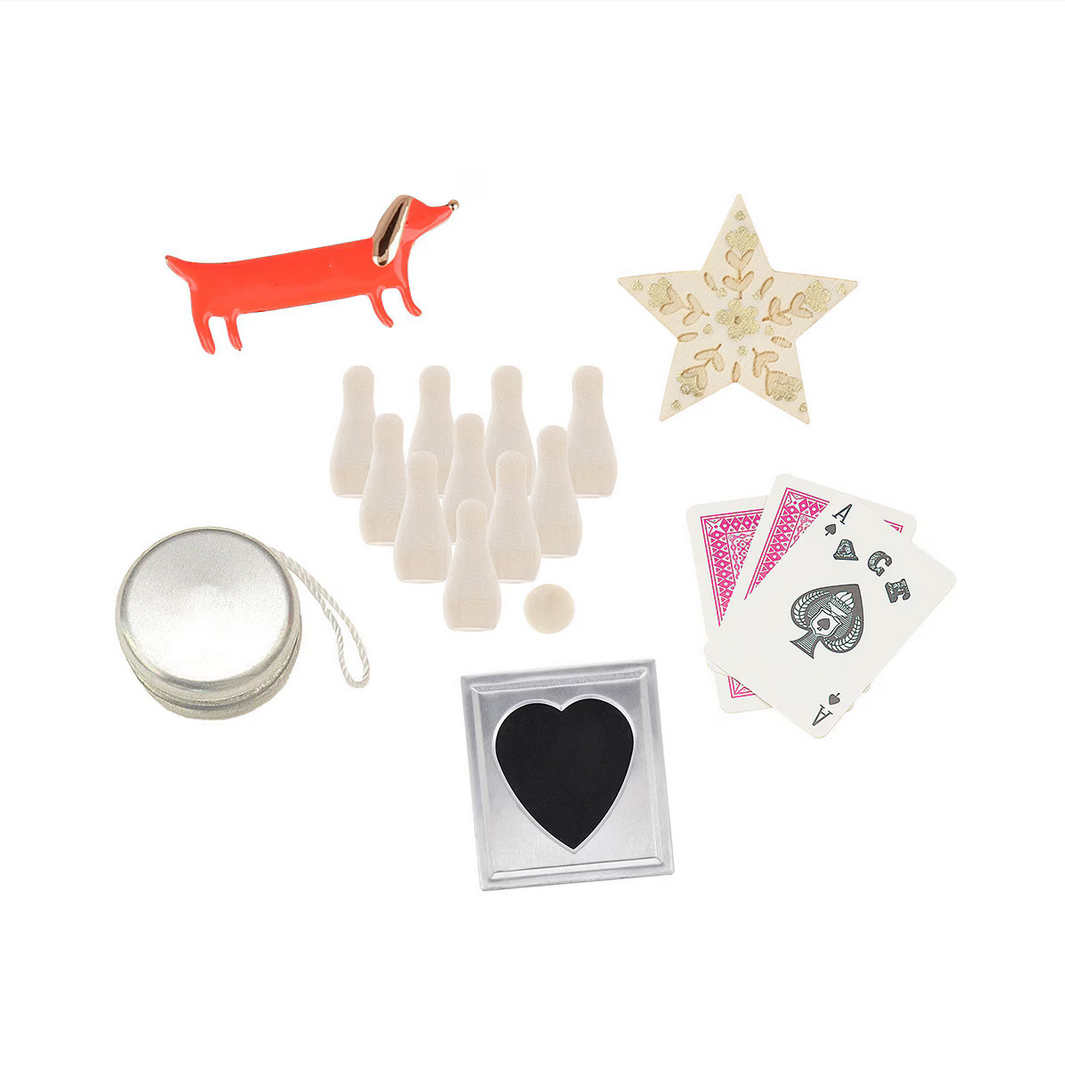 Collection of small items including a tin, playing cards, star-shaped object, and more on a white background.