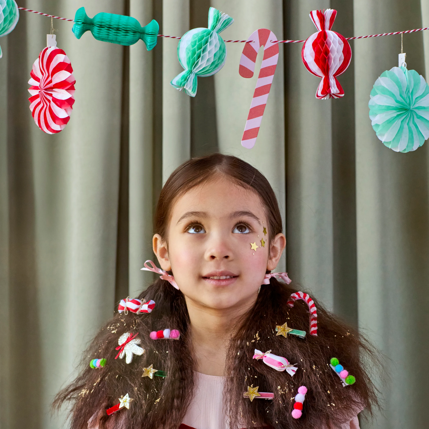 Young girl with candy-themed hair accessories in front of a candy-themed decoration