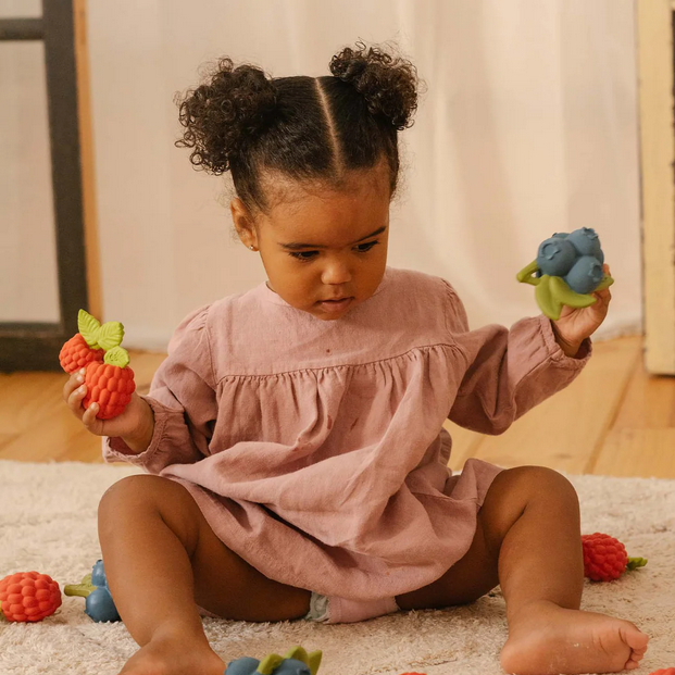 Child playing with colorful toys on a carpeted floor