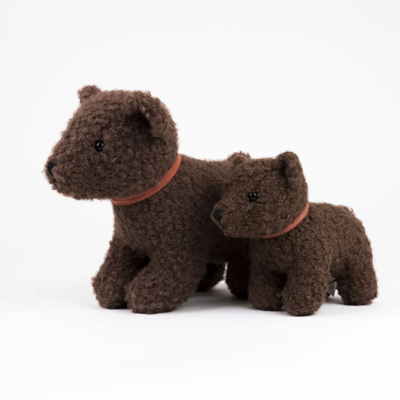 Two brown teddy bears with orange collars on a white background