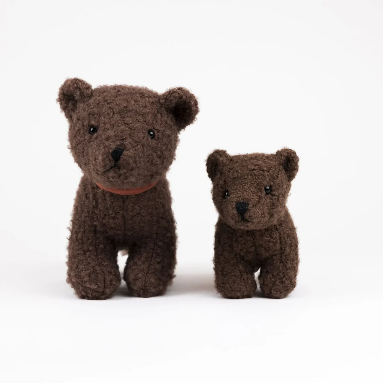 Two brown teddy bears of different sizes on a white background