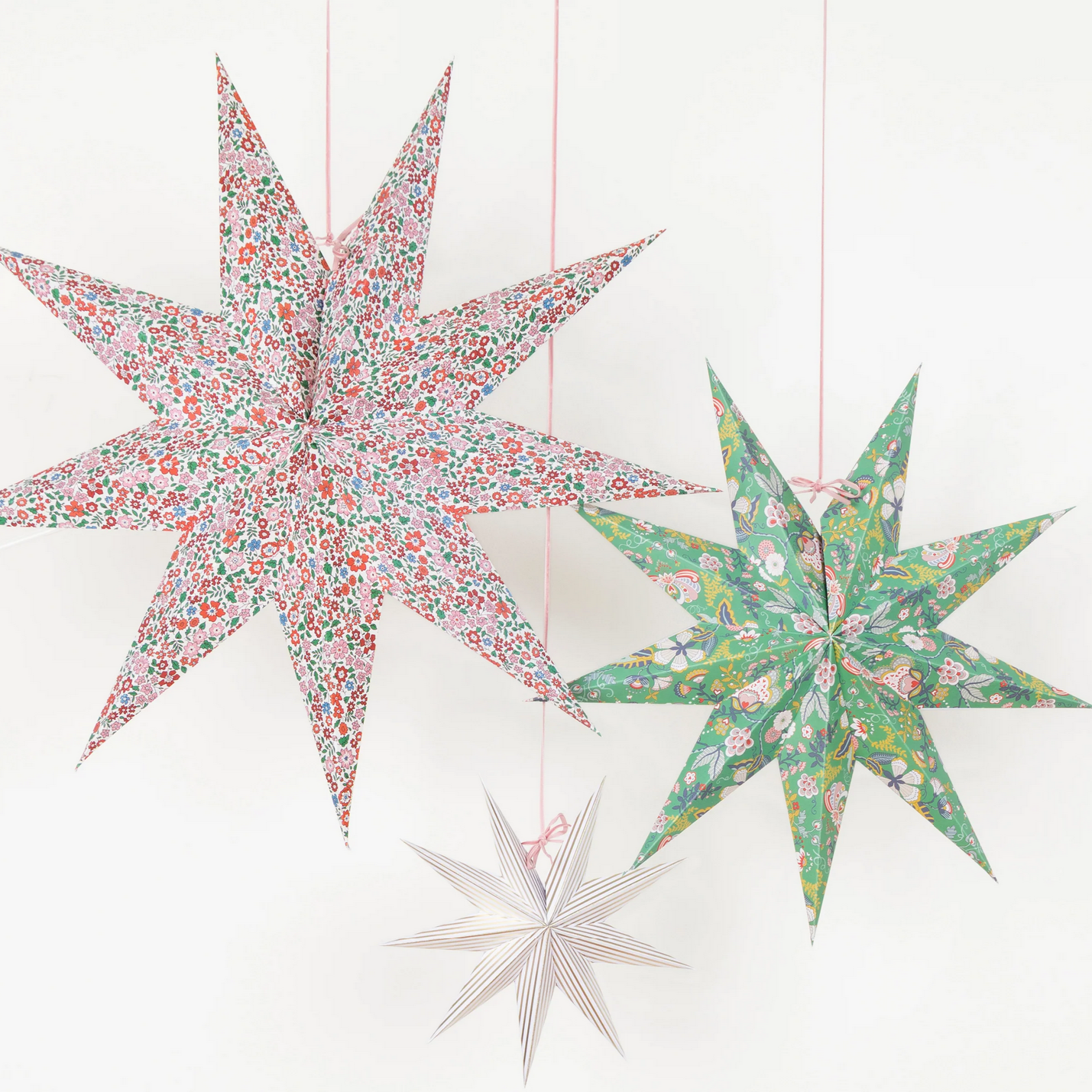 Three floral-patterned star-shaped decorations on a white background