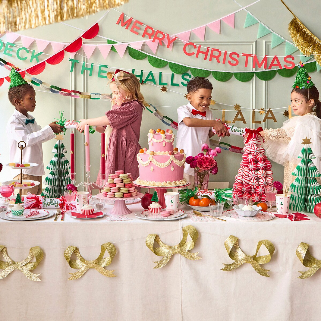 Children at a Christmas party with a cake and festive decorations.