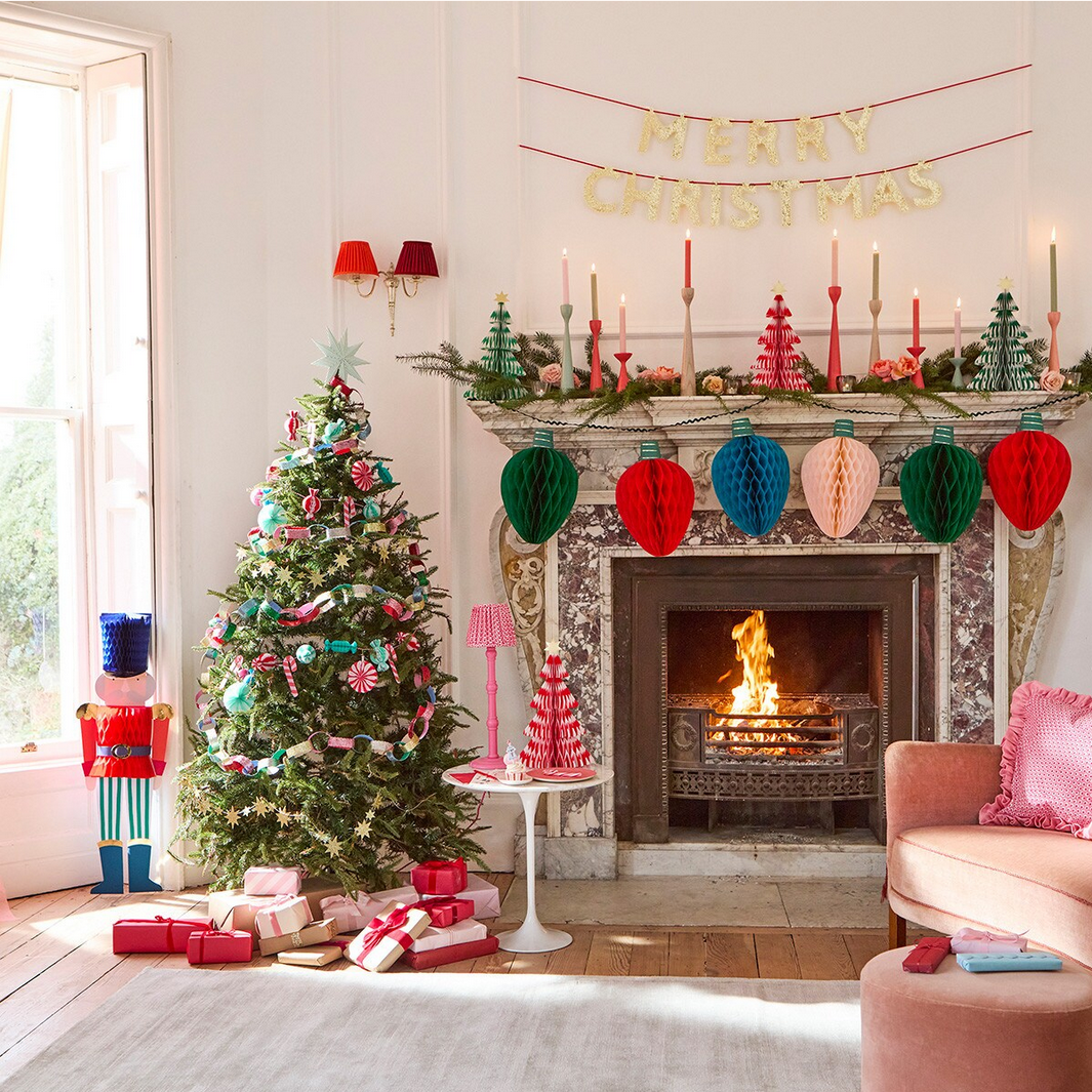 Cozy living room decorated for Christmas with a tree, fireplace, and festive decorations.