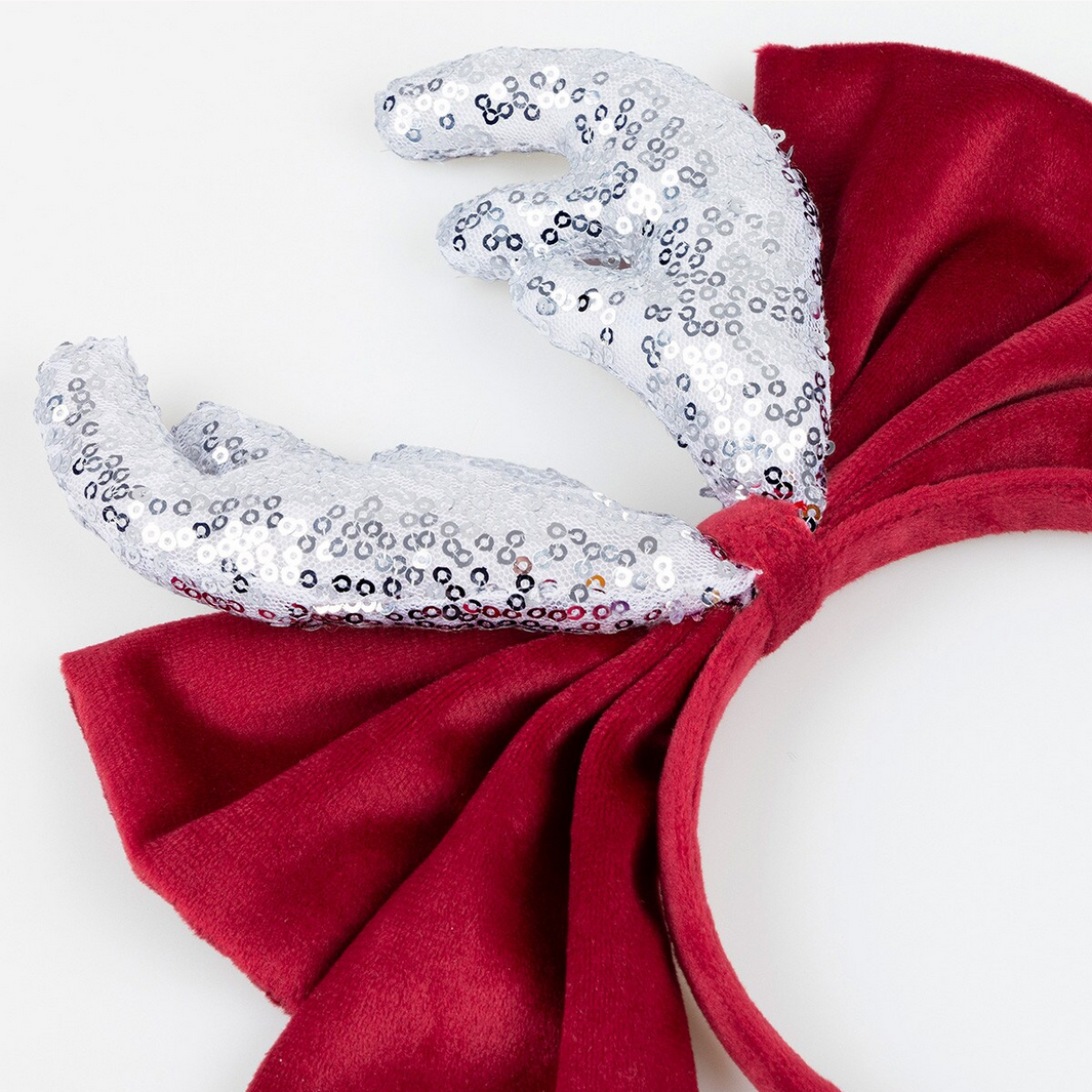 Decorative headband with silver sequin bow and red fabric bow on a white background