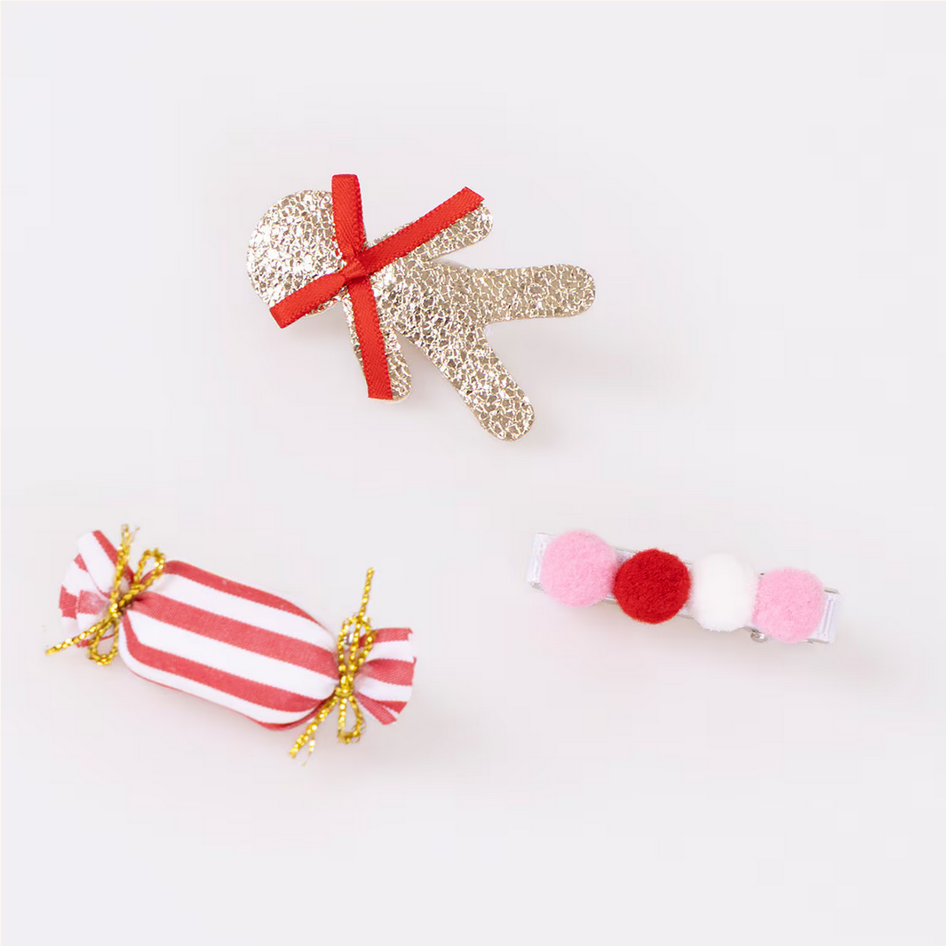 Decorative items including a glittery hand, striped candy, and pom-pom necklace on a white background