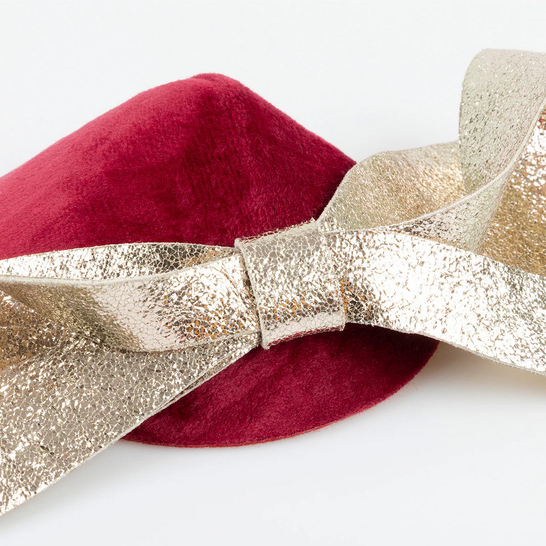 Red beret with a gold glittery bow on a white background