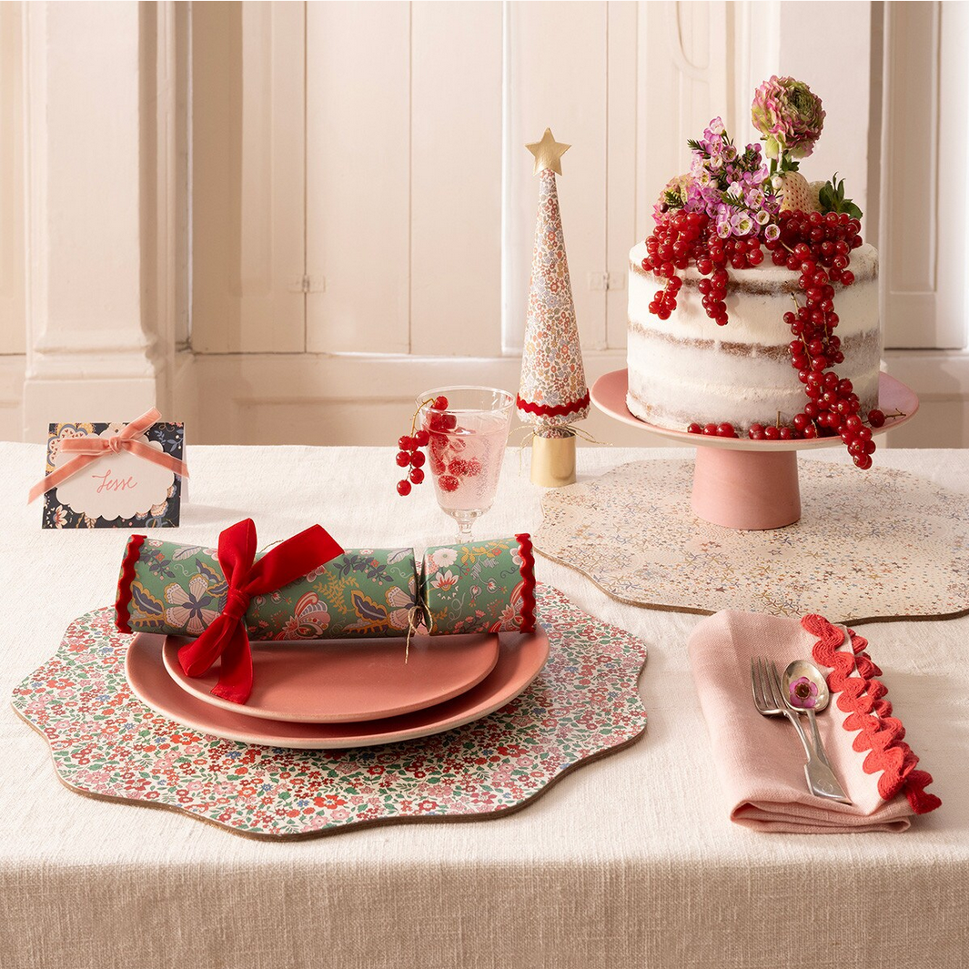Decorative Christmas table setting with a cake, crackers, and place settings.