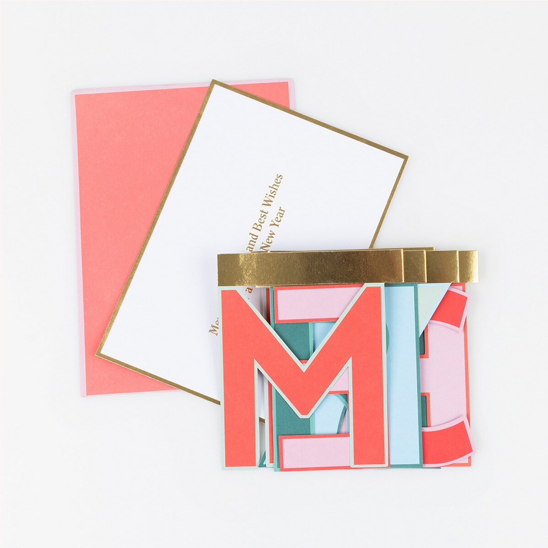 Stack of colorful greeting cards with a gold band on a white background