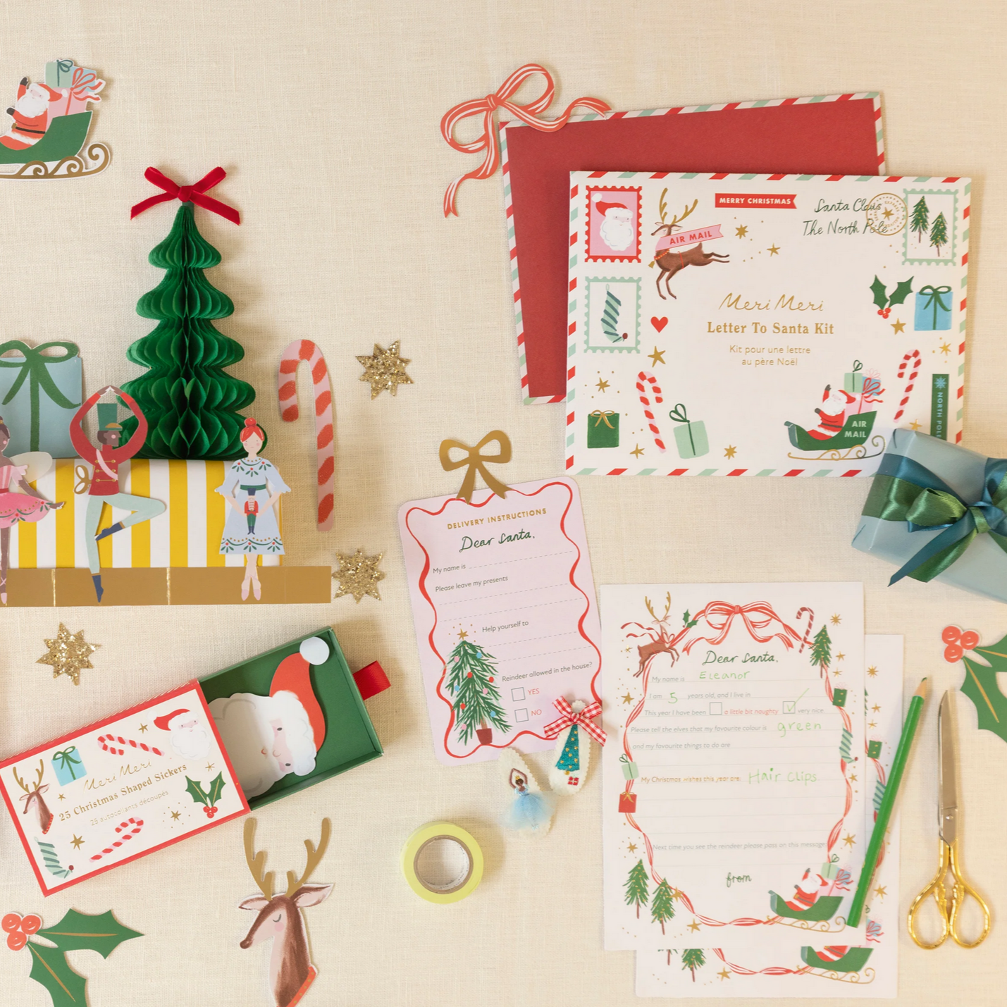 Christmas-themed stationery set with envelopes, cards, and decorative items on a beige background.