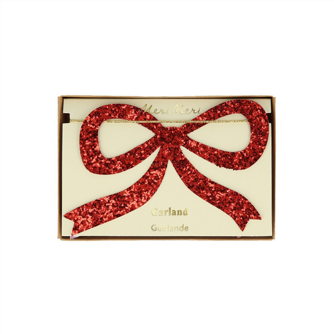 Decorative card with a red glitter bow on a beige background