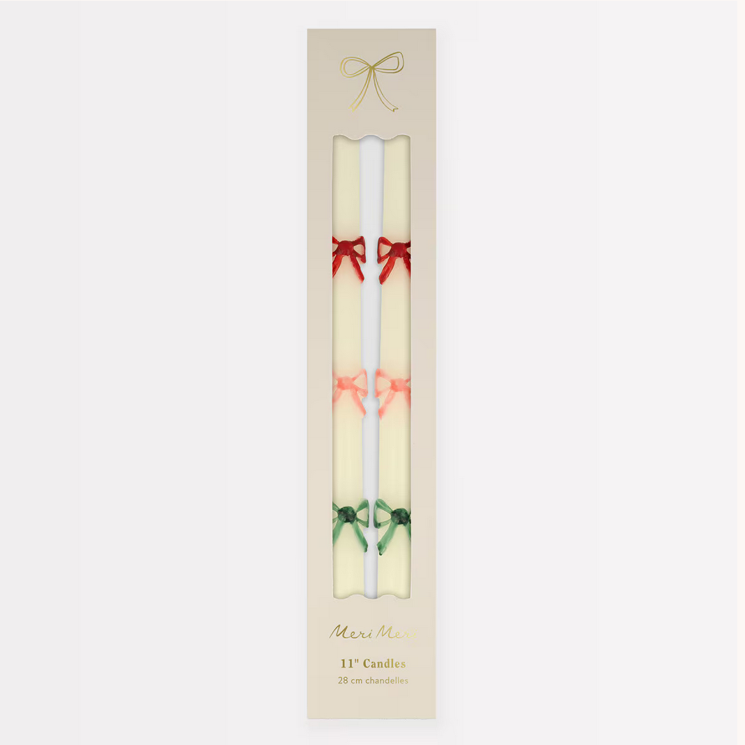Two candles with decorative bows in a Meri Meri branded box on a white background