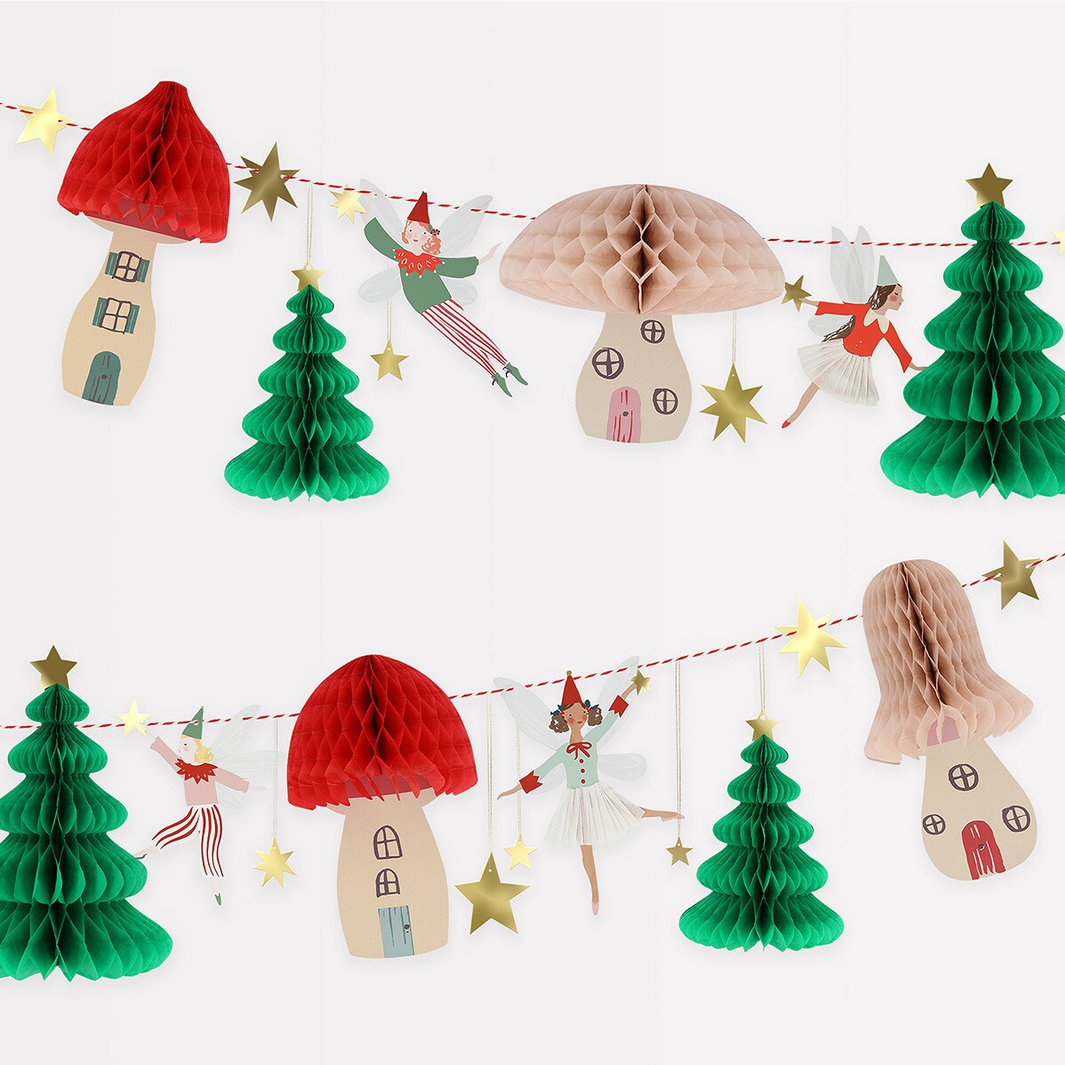 Decorative string with paper houses, trees, and fairies on a white background
