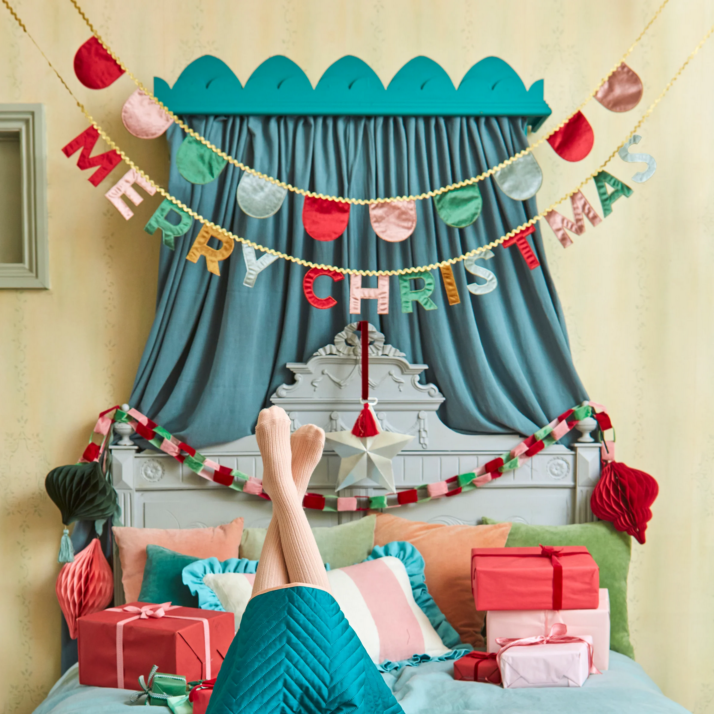 Decorated room with Christmas decorations, including a 'Merry Christmas' banner and presents.