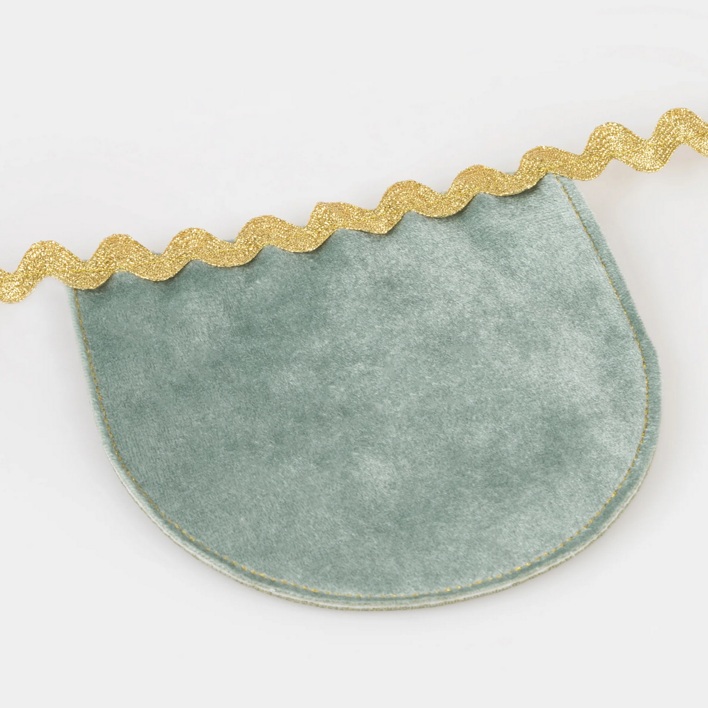 Green crescent-shaped placemat with gold decorative edge on a white background