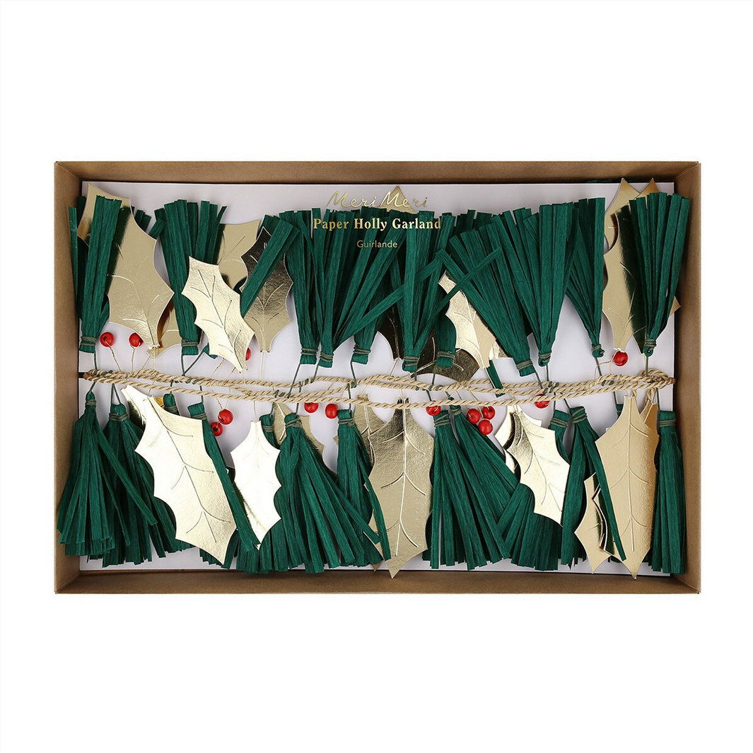 Decorative paper holly garland with green leaves, gold berries, and red berries in a box.