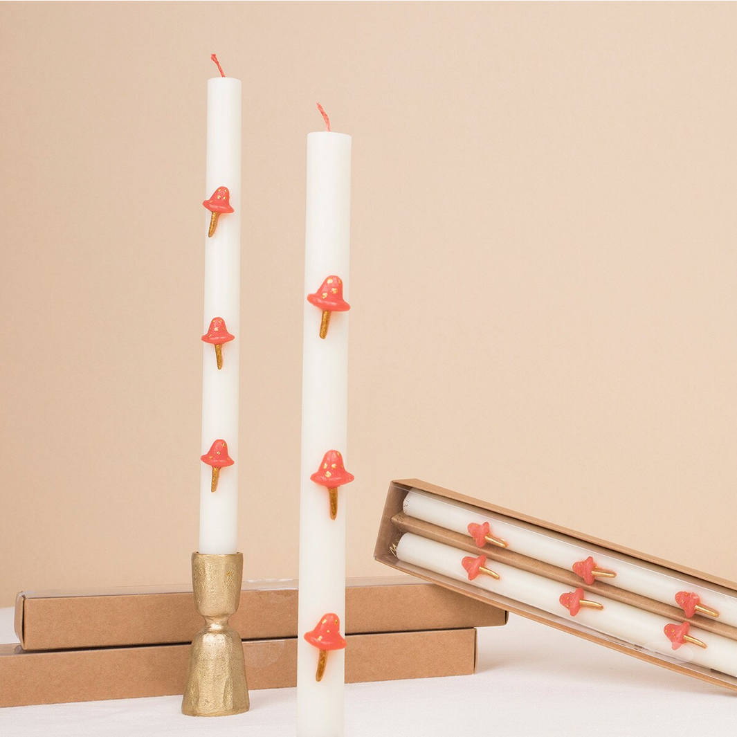 White candles with red decorative elements on a beige background