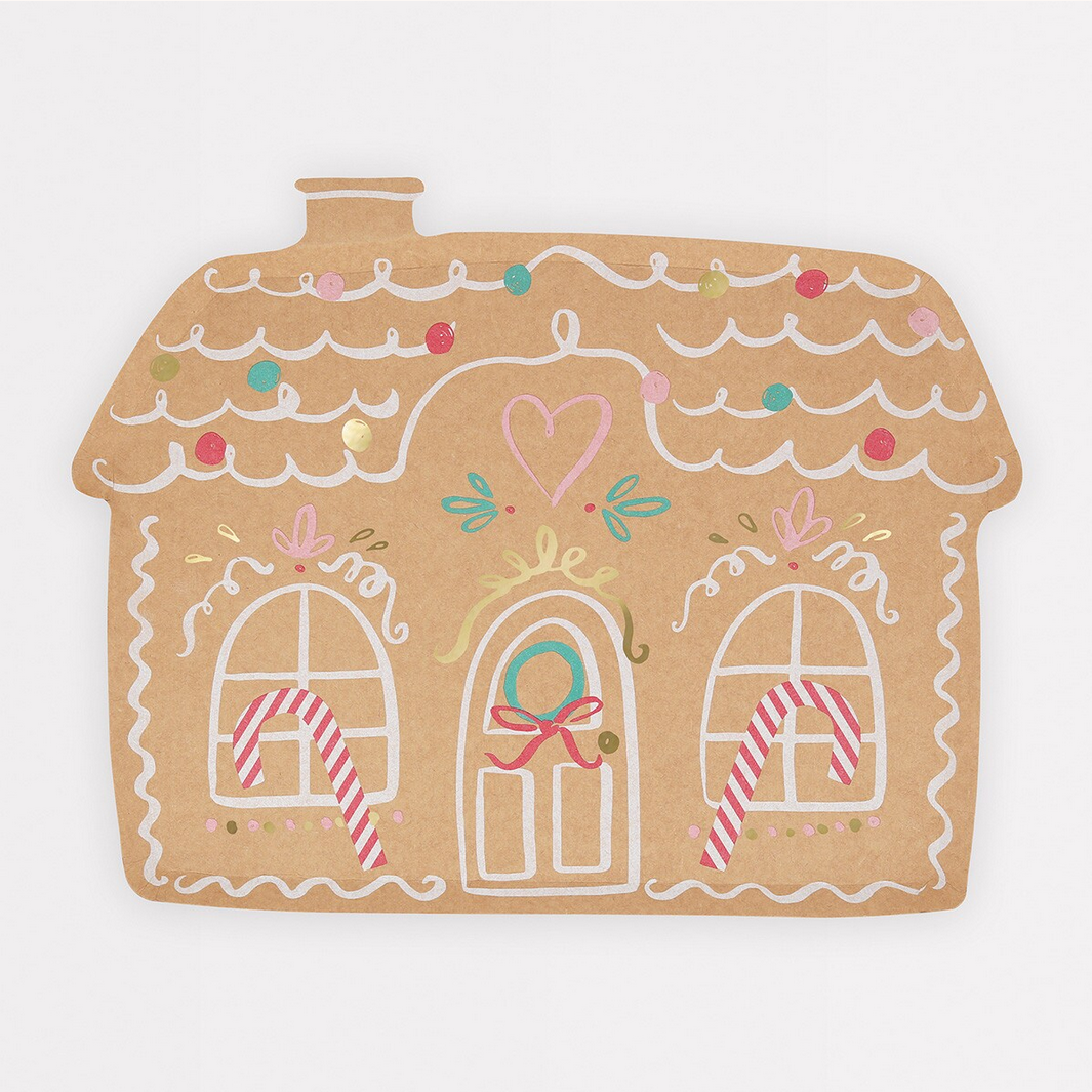 Decorative gingerbread house-shaped mat with colorful icing details on a white background