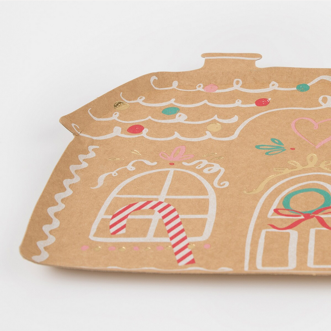 Gingerbread house-shaped card with candy cane details on a white background