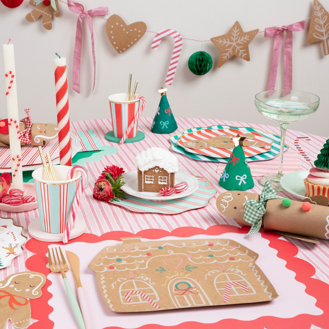 Christmas-themed table setting with gingerbread decorations and festive tableware.