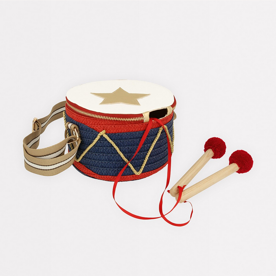 Children's drum with star design and two mallets on a light gray background