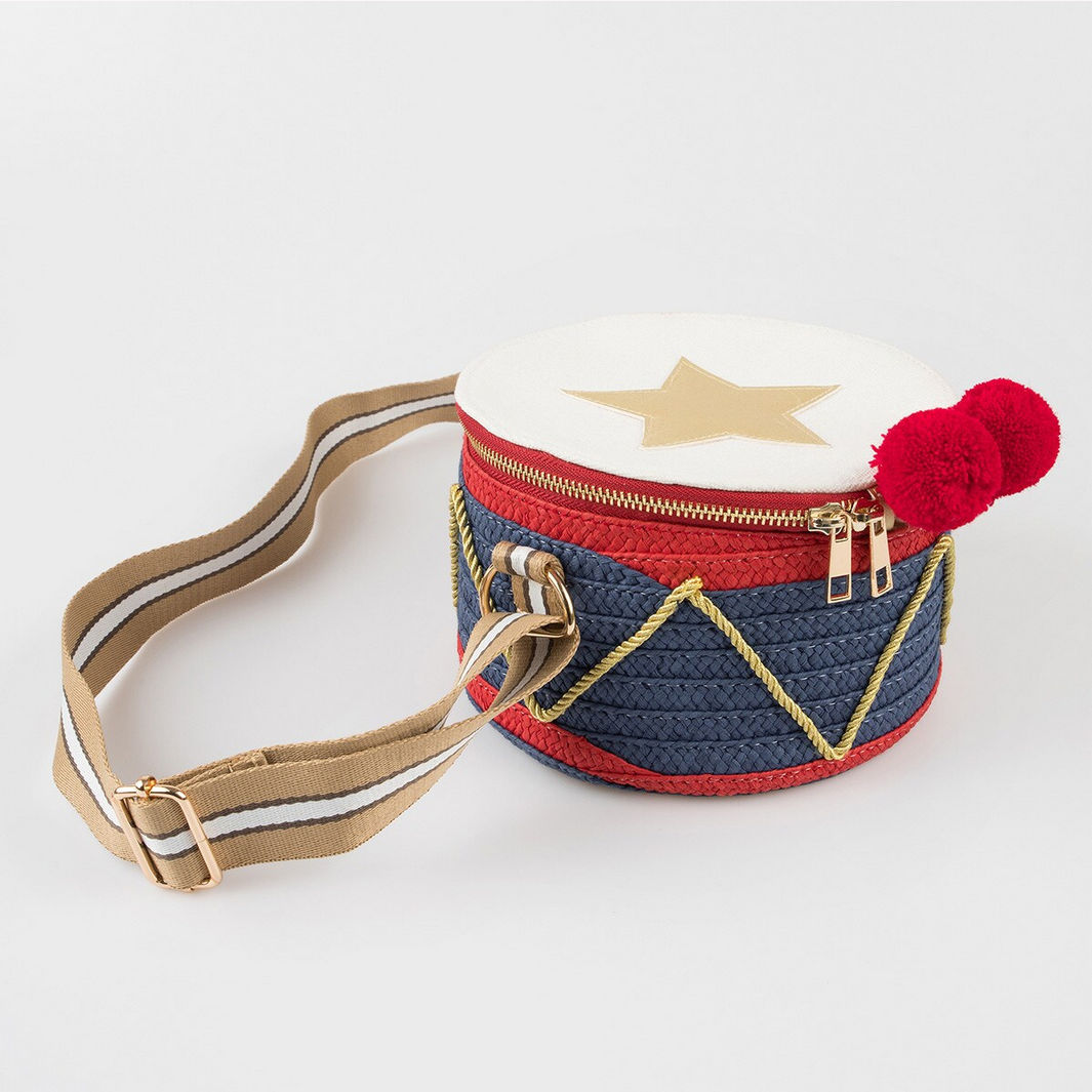 Small round bag with star design, red band, and pom-pom on a white background