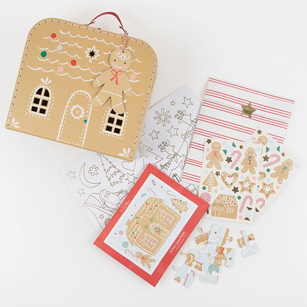 Gingerbread-themed stationery set including a house-shaped pouch, cards, and stickers on a white background.
