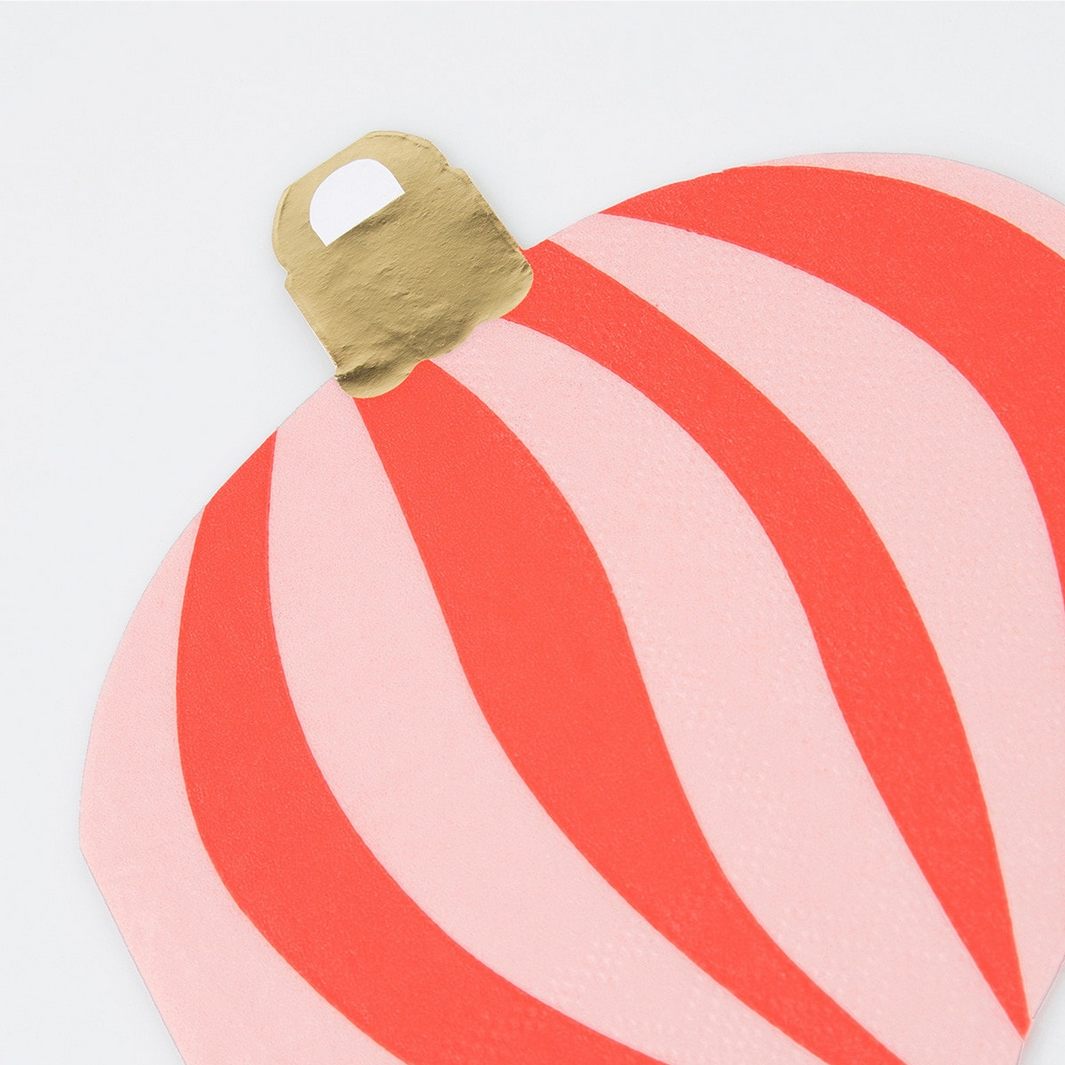 Red and pink striped object with a gold handle on a light gray background