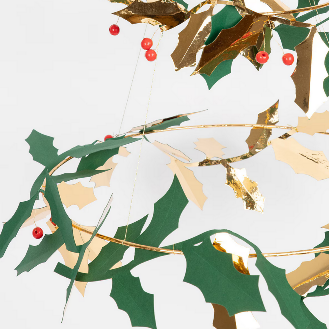 Decorative holly leaf and berry ornament on a white background