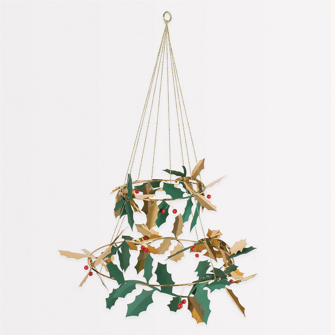 Hanging decorative wreath with green leaves and red berries on a white background