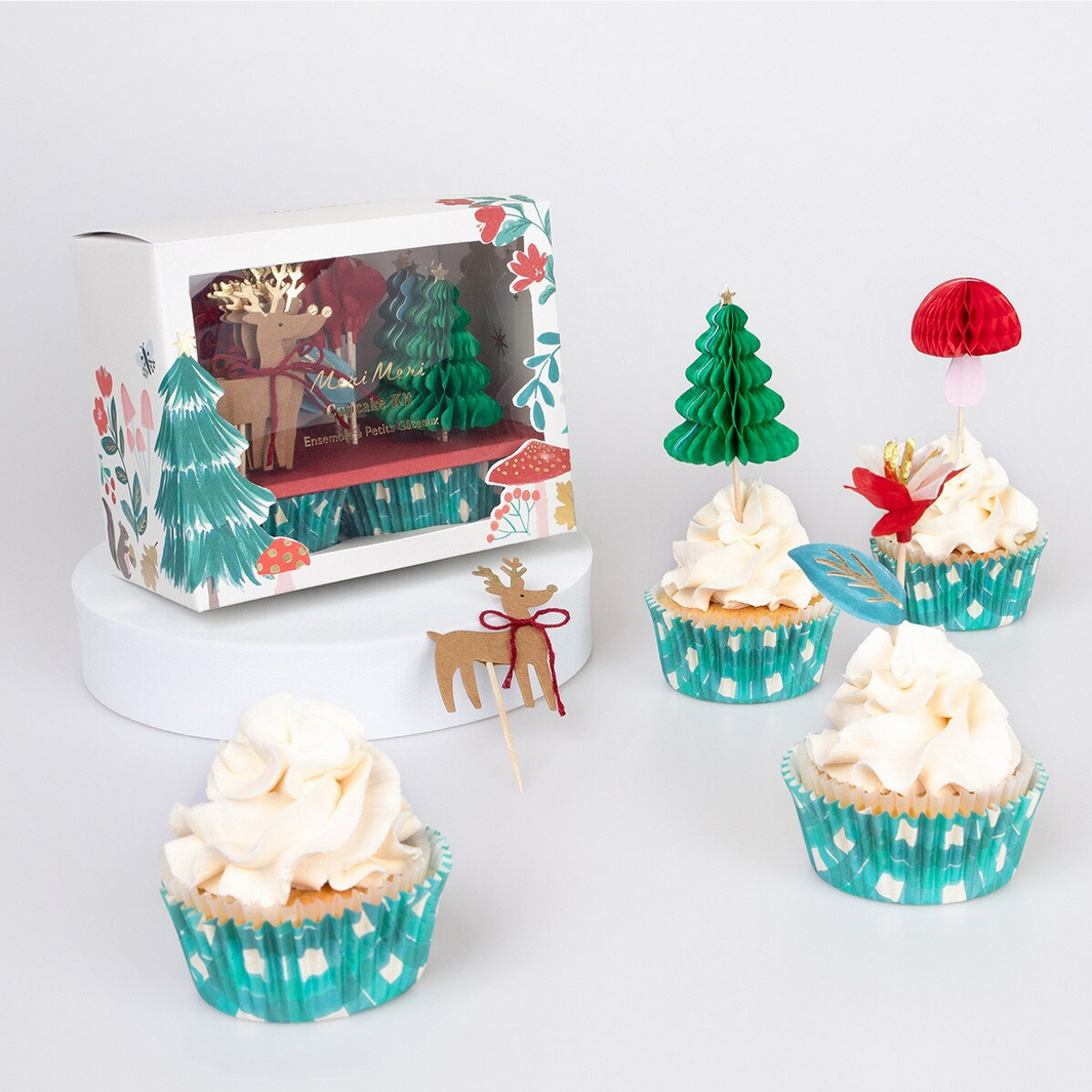 Cupcakes with Christmas-themed decorations and a gift box on a white background