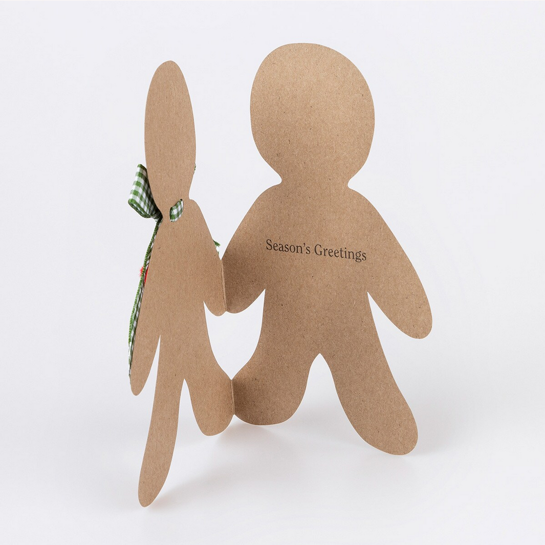 Two brown paper cutout figures holding hands with a green ribbon, on a white background.