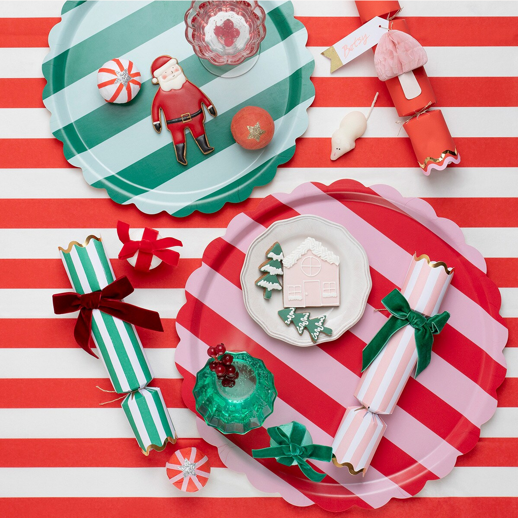 Christmas-themed paper plates and decorations on a red and white striped background