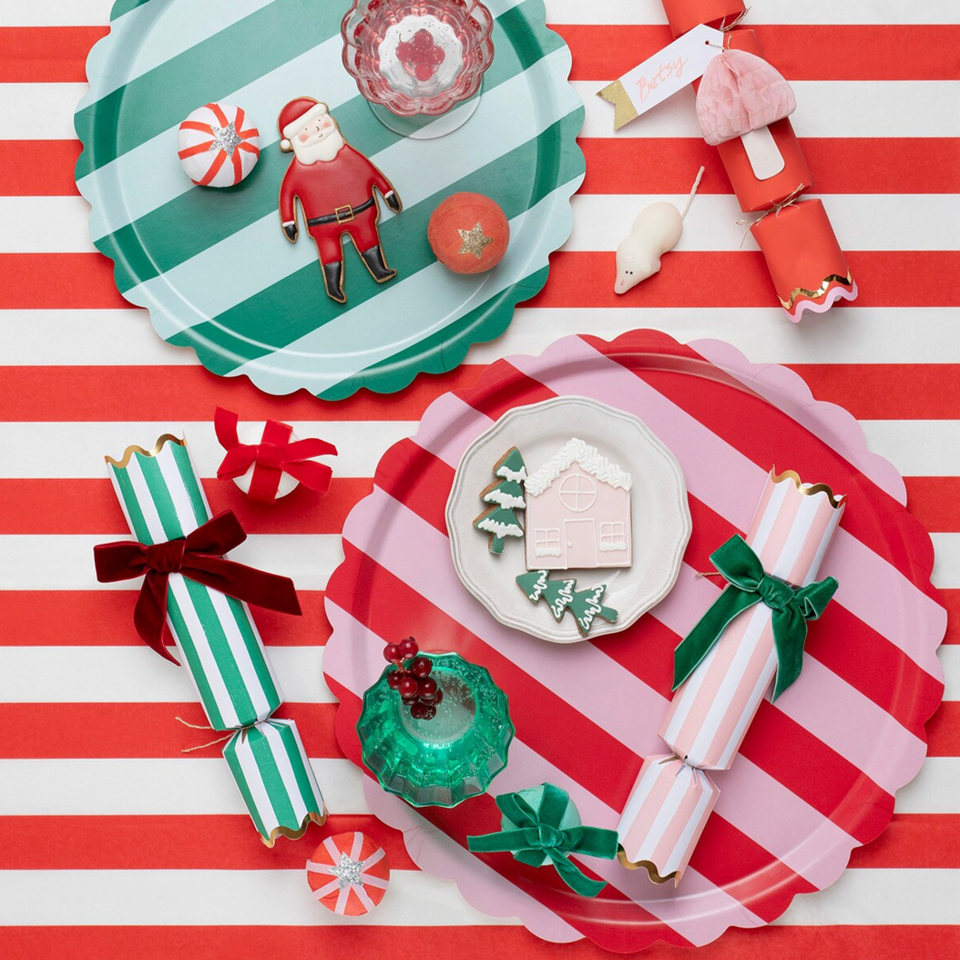 Christmas-themed paper plates and decorations on a red and white striped background